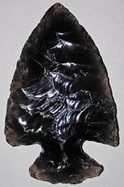 A piece of obsidian that has been crafted into an arrowhead through a process called knapping.